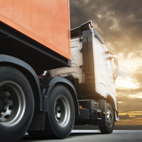 Semi truck trailer driving on road at sunset sky. Cargo freight truck, Logistics and transportation.