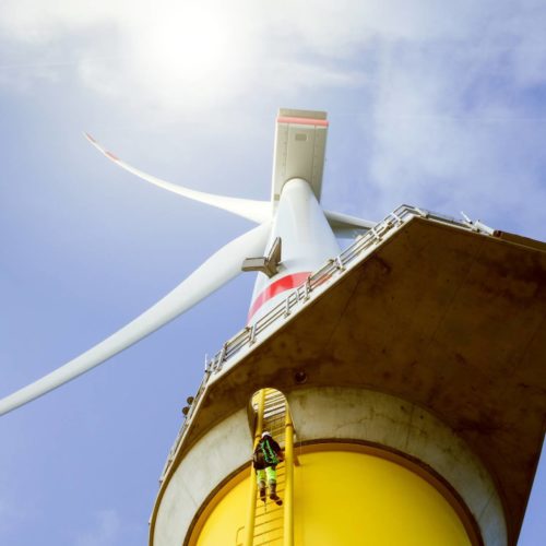 Manual high worker climbing on biggest wind-turbine