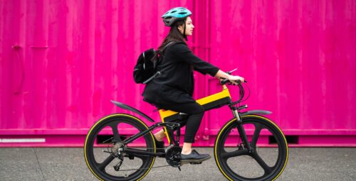 woman riding bike with pink background